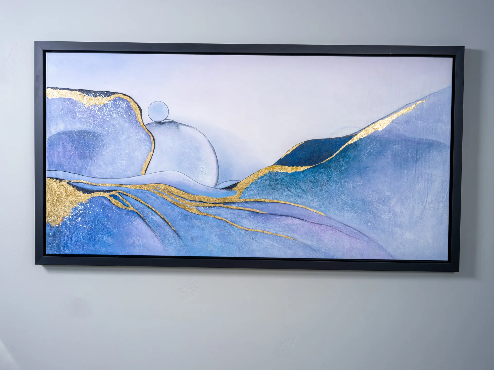 Close-up of abstract wall art featuring blue tones and gold accents, staged by Stately for a modern luxury interior.