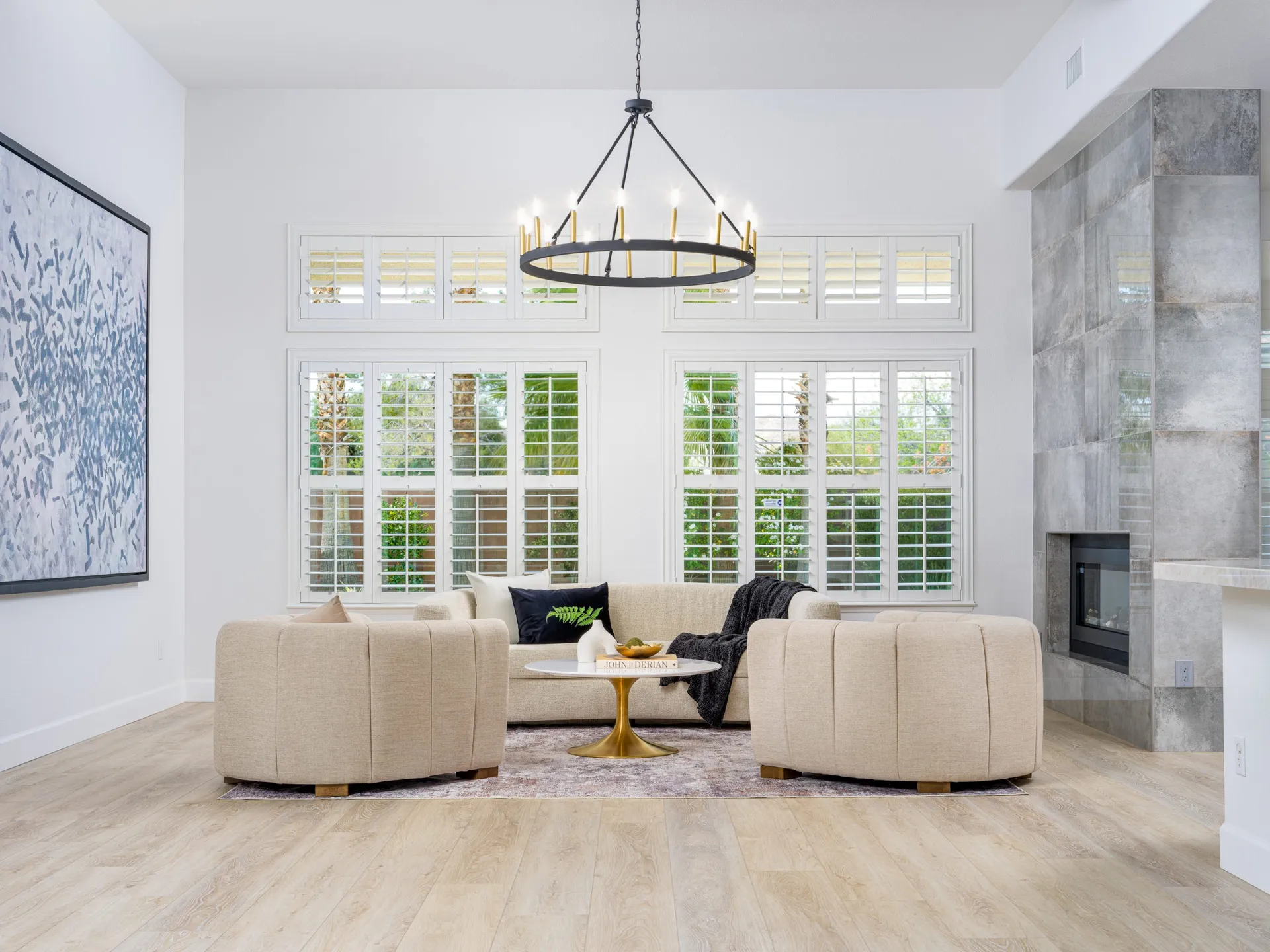 Modern living room with beige chairs, white sofa, and gold coffee table