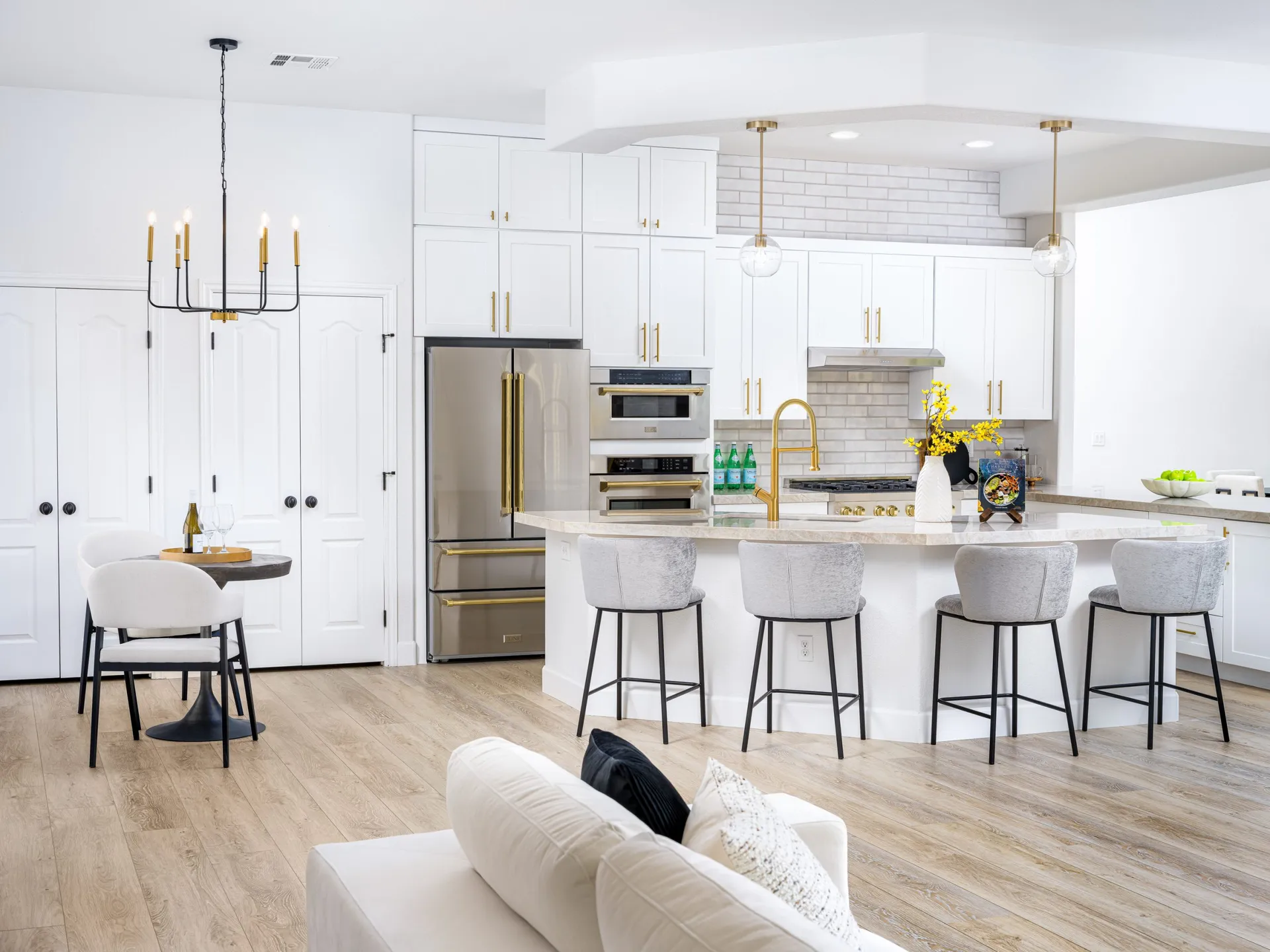 Modern kitchen with large island, white cabinetry, and gold accents