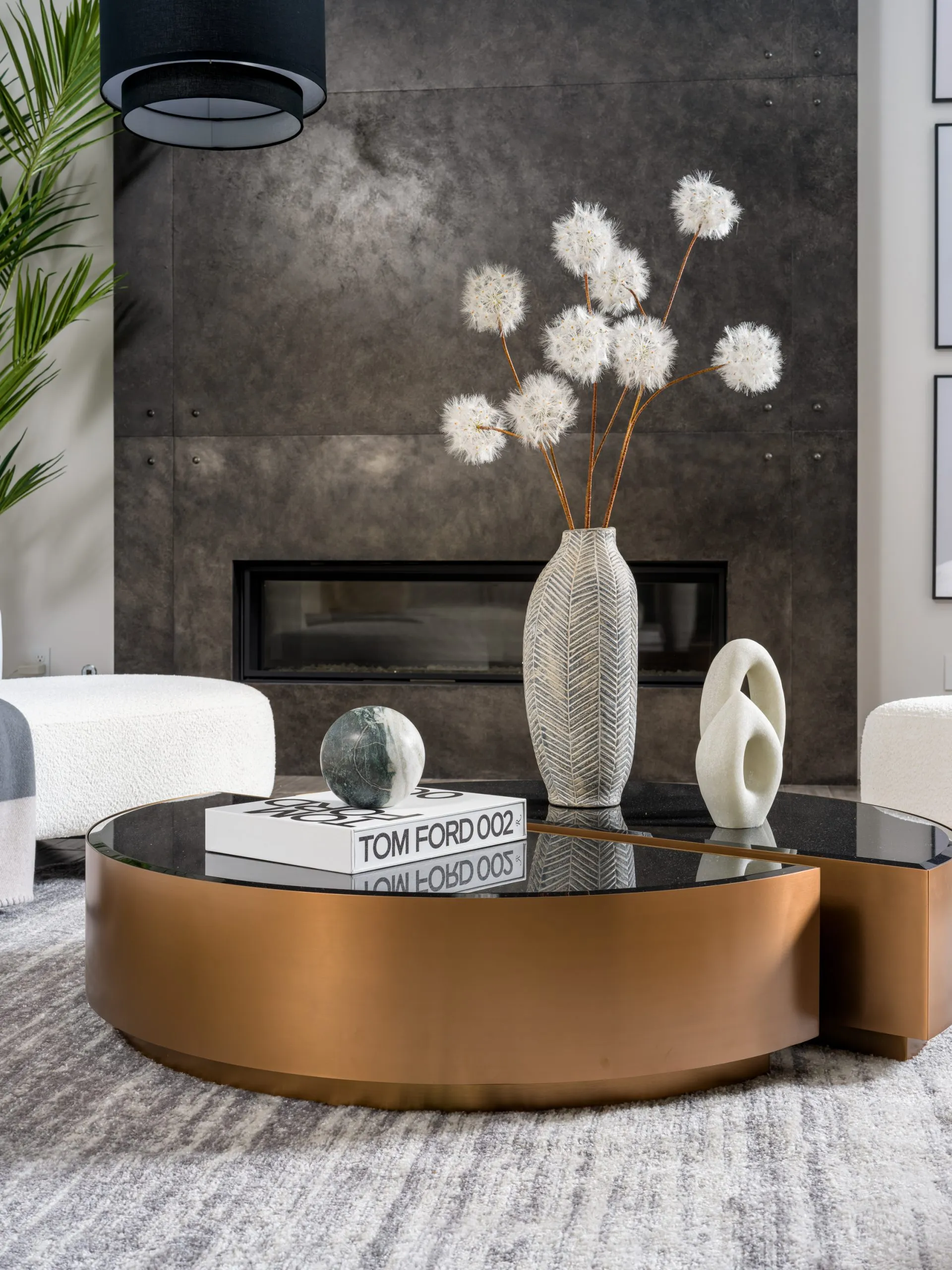 Modern coffee table with metallic base, glass top, and decorative items