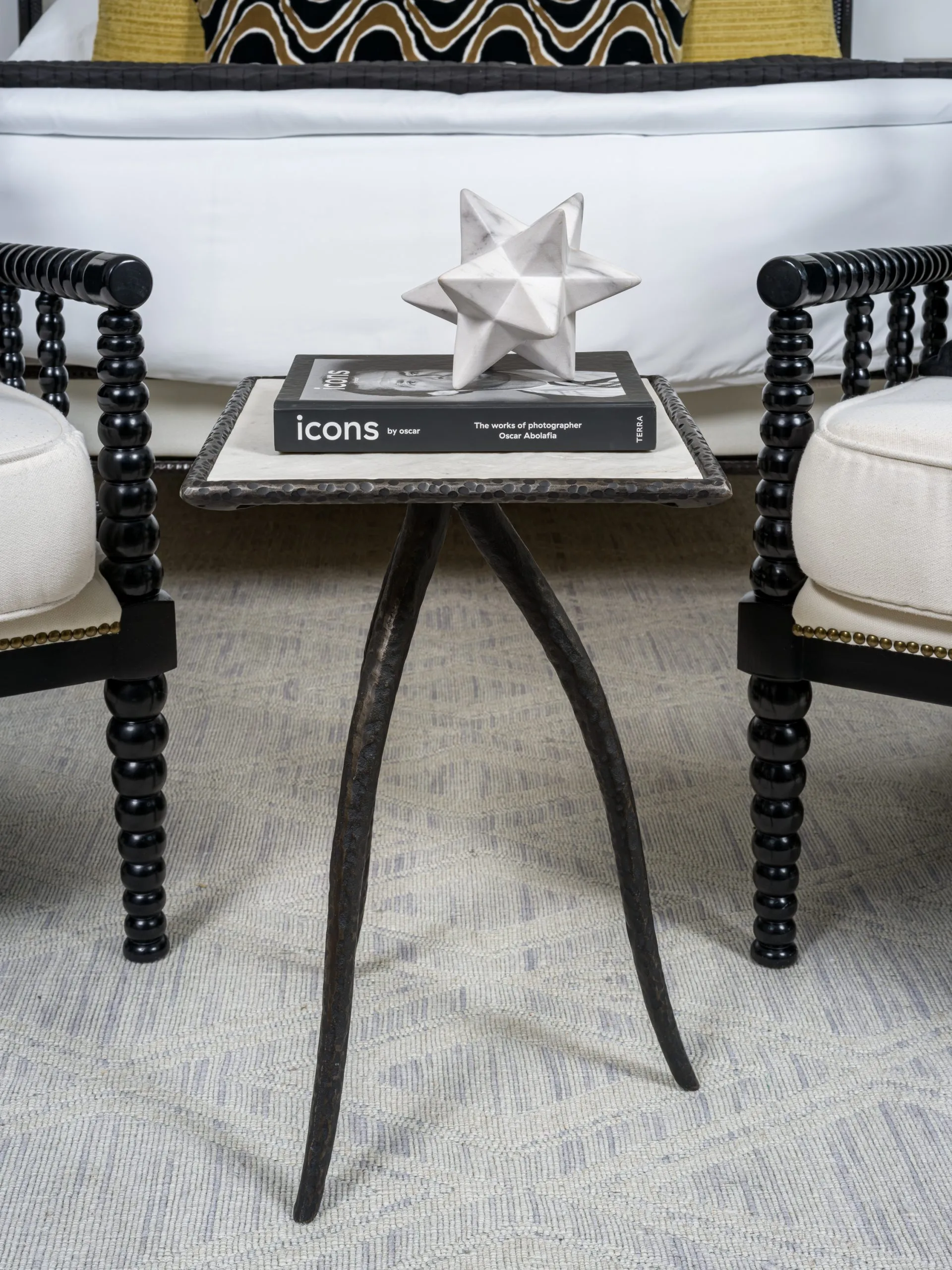 Small side table with metal base, decorative item, and book