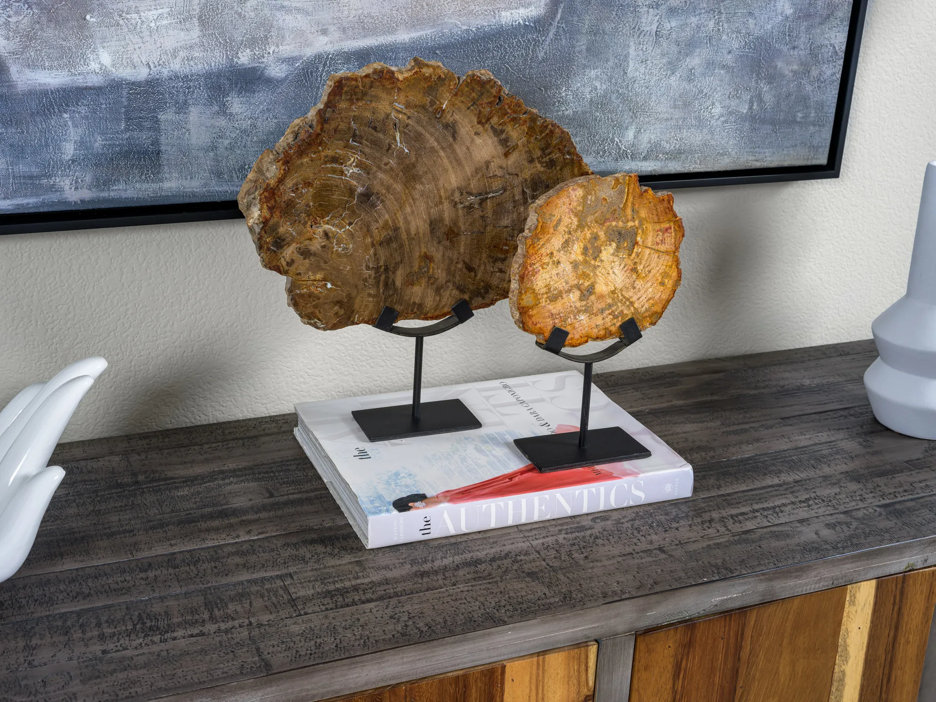 Two petrified wood slices on stands displayed on a console table.