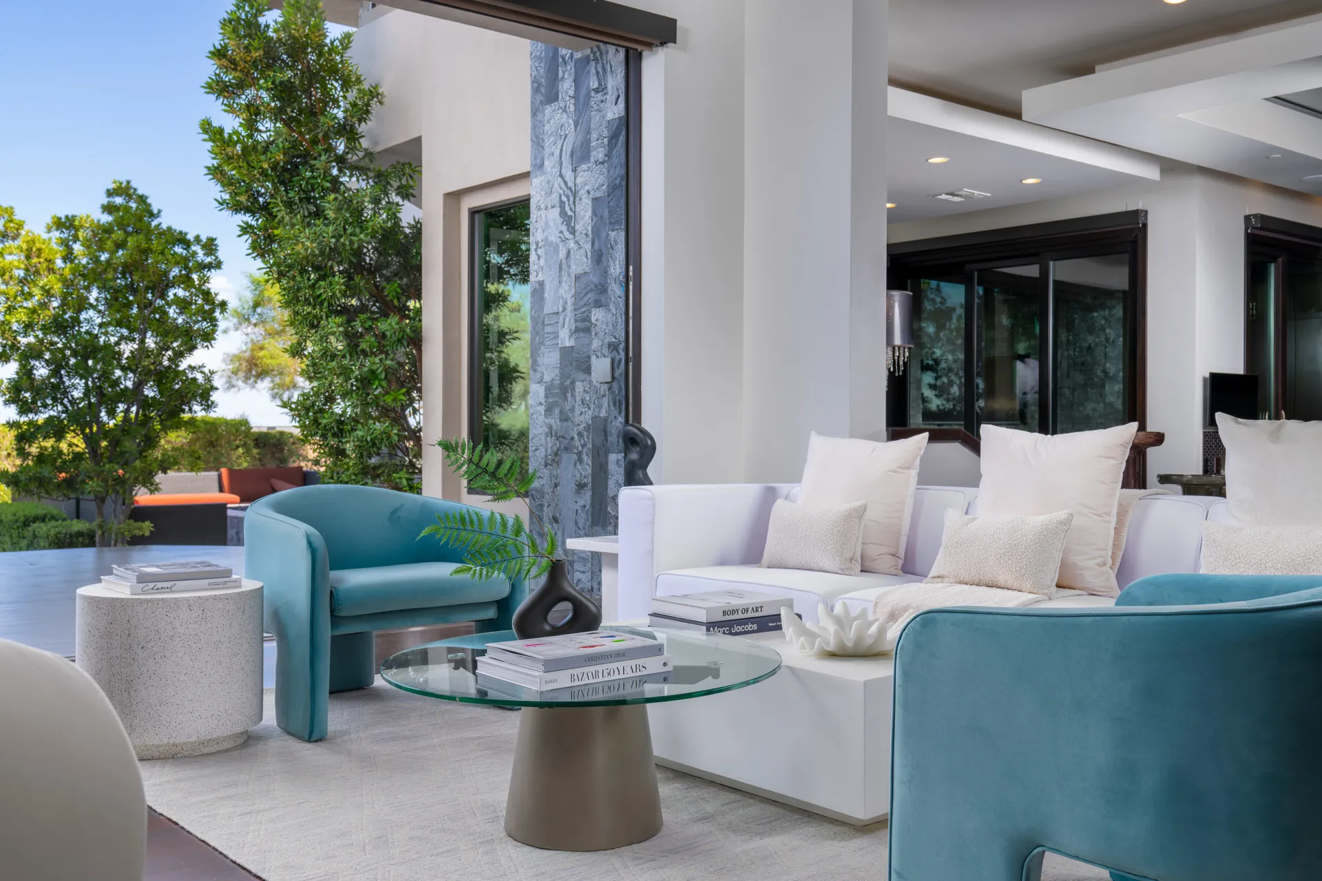 Outdoor seating area with modern furniture and greenery.
