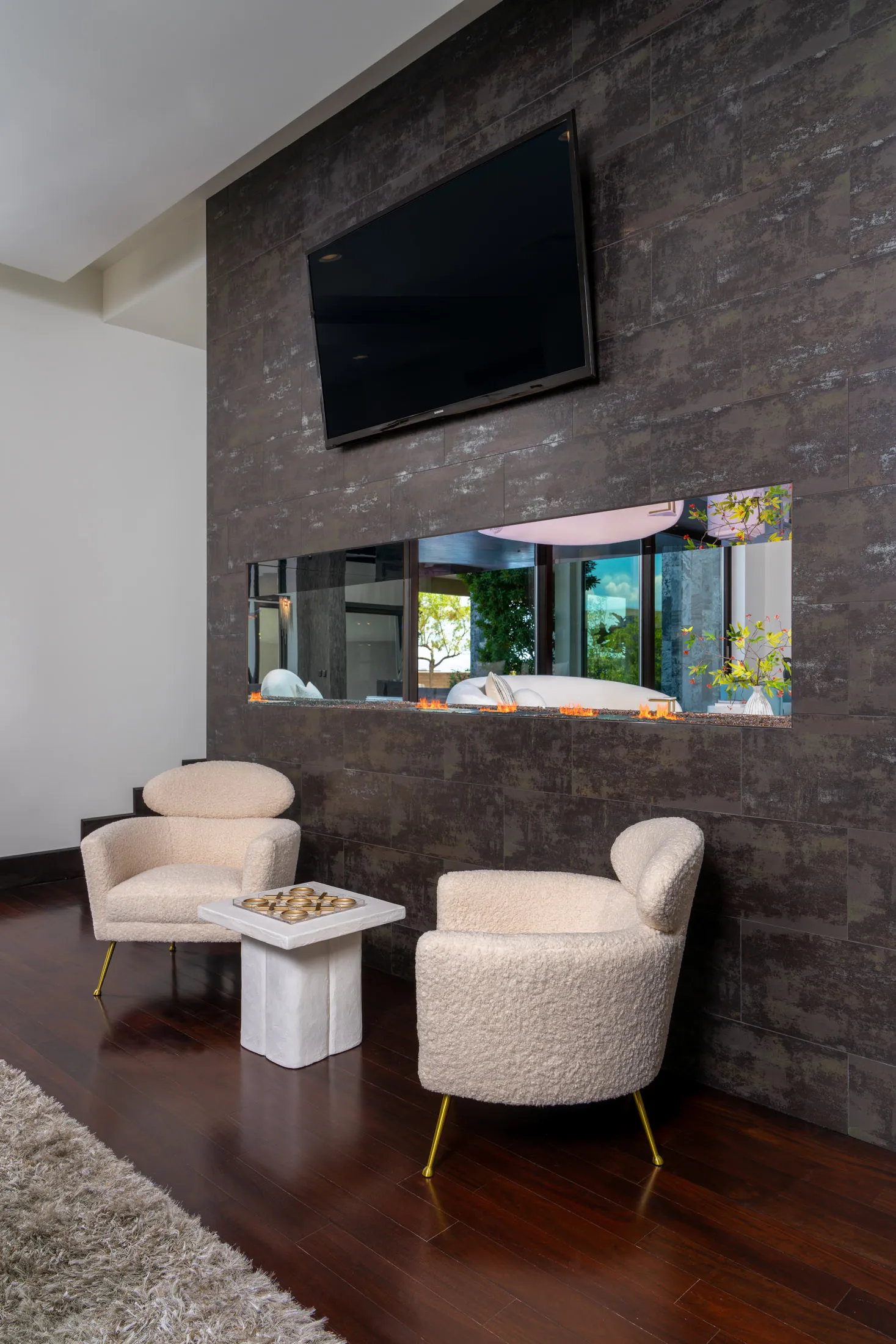 Cozy seating area with chairs, small table, and large wall-mounted TV.