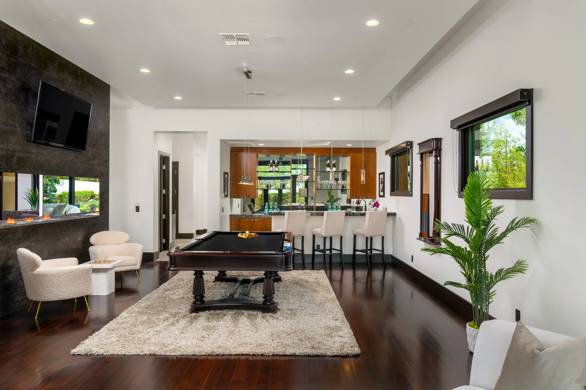Game room with billiard table, seating, and large window.