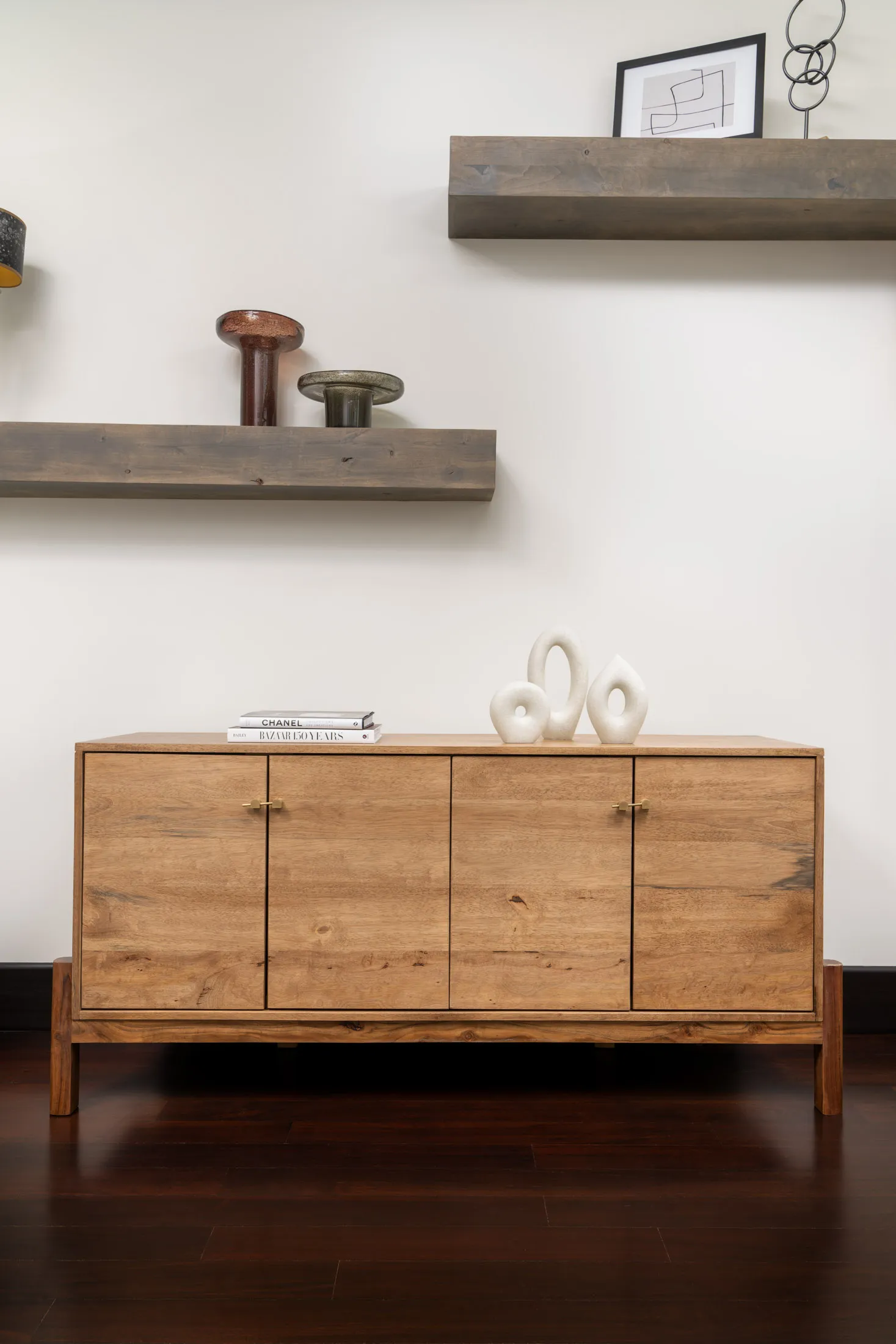 Wooden console table with floating shelves and decorative items.