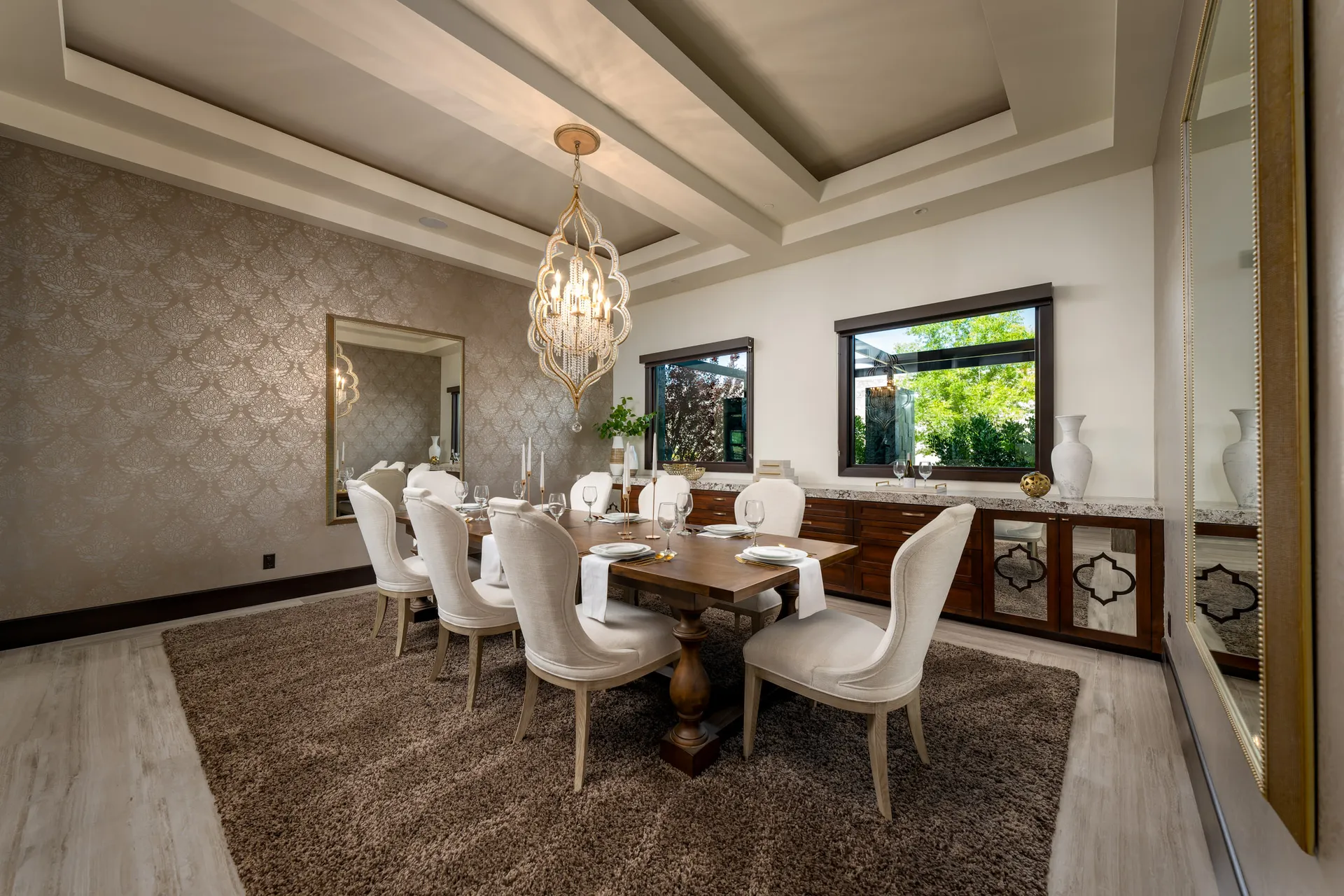 Elegant dining room with wooden table, upholstered chairs, and chandelier.