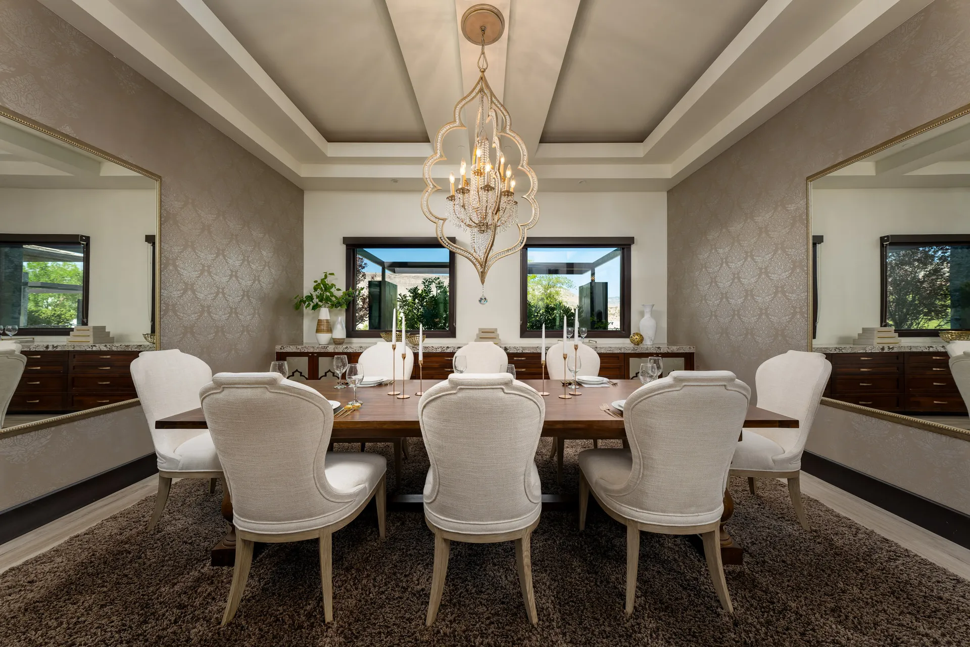 Elegant dining room with wooden table, upholstered chairs, and chandelier.