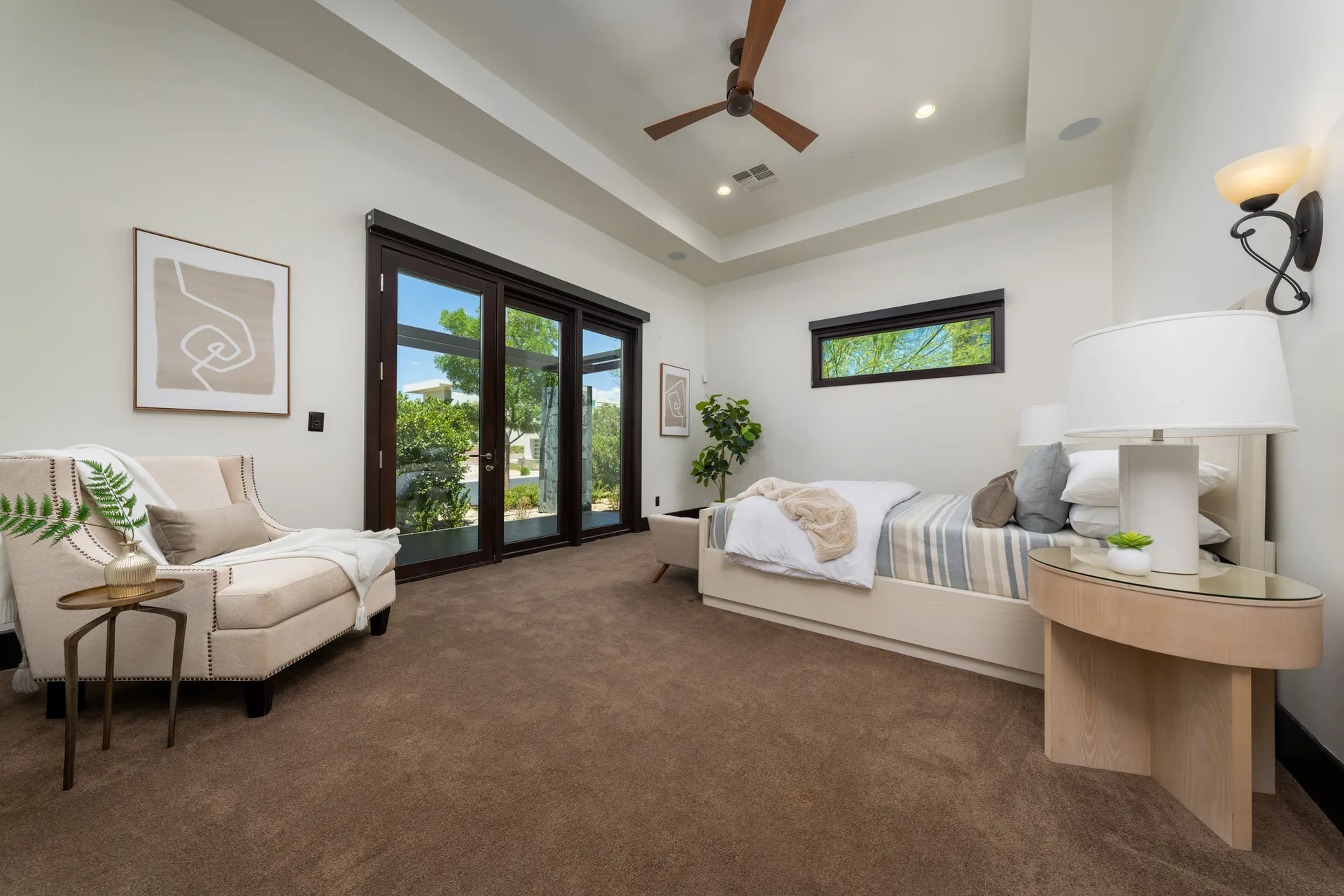 Minimalist bedroom with large bed, bench, and neutral color palette.