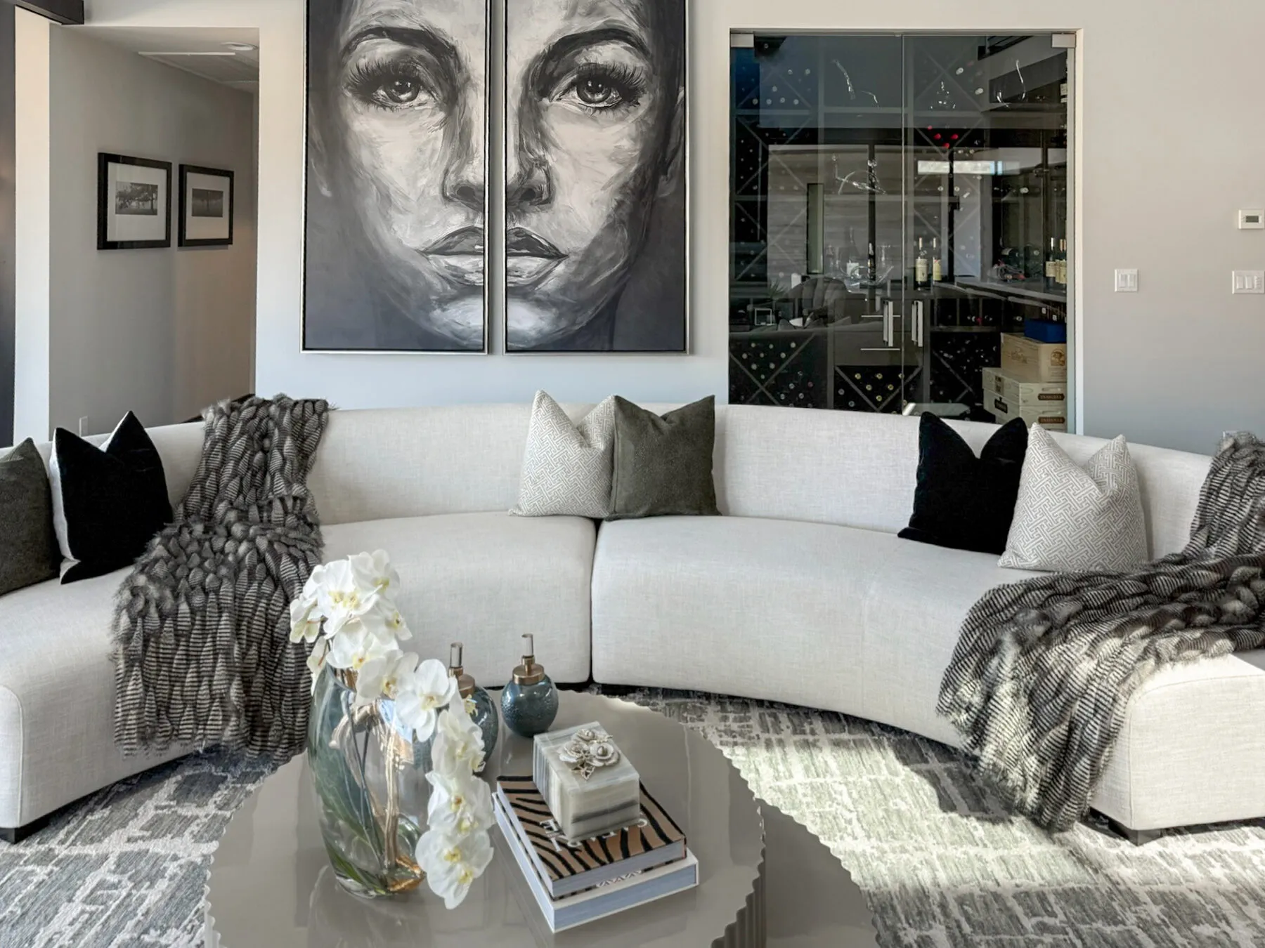 Curved Sectional Facing a Portrait Diptych and Wine Wall