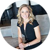 A professional woman wearing business attire, smiling at the camera.