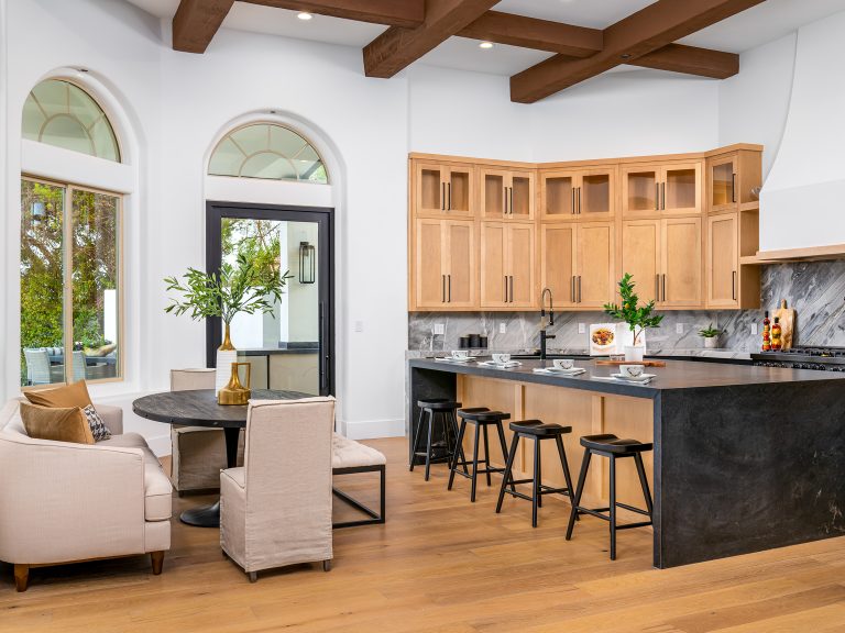 Stunning Home Staging in a bright kitchen with warm wood cabinetry, black stone countertops, and a cozy breakfast nook at Yorkridge Court.